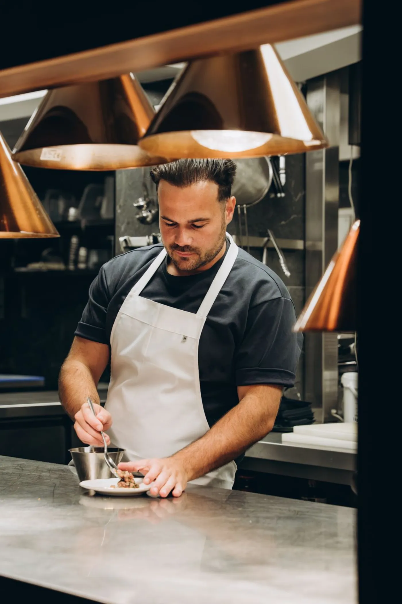 Chef Julius Nuiten plating a dish in the Le Souterrain kitchen